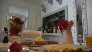 A dining area with a chalkboard menu, decorative bunny heads, and a vase with flowers. - Berkeley House (Durban North)