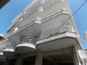A multi-story building with balconies and a spiral staircase. - Zeta's Apartments (Sarandë)