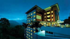A multi-story hotel with a modern design, featuring balconies and large windows. - Gokulam Park Munnar (Devikolam)