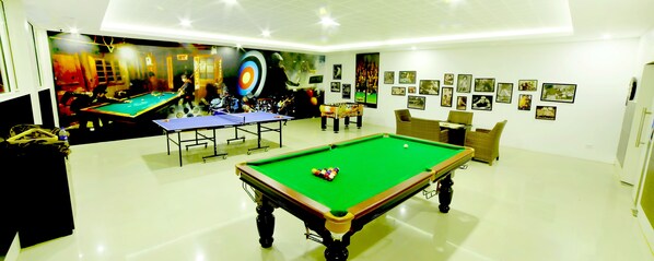 A billiards room with a pool table, a snooker table, and a foosball table. - Gokulam Park Munnar (Devikolam)