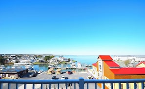 Un puerto deportivo con barcos amarrados, cielo azul despejado y edificios al fondo.