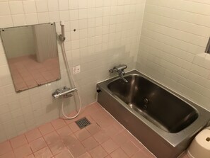 Ein Badezimmer mit einer Badewanne, einer Dusche und einem WC.