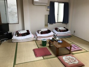 Habitación cuádruple básica | Zona de estar | Una televisión de pantalla plana