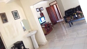 Un amplio espacio de estar con televisor, pileta y sofá.