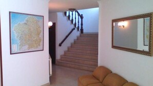 A staircase with wooden handrails leading to an upper floor. - Pensión Rey (Isla de Arosa)