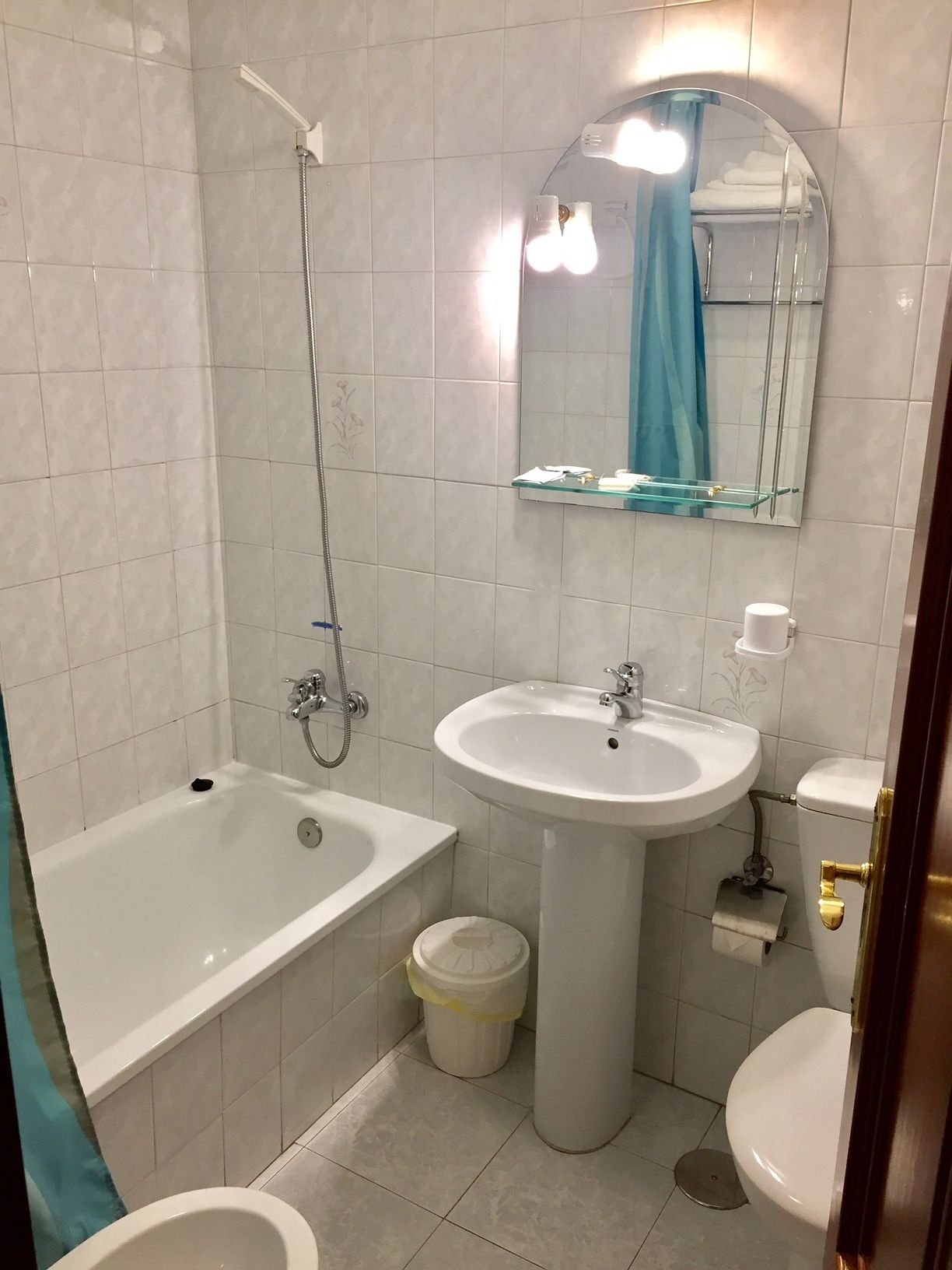 A bathroom with a bathtub, a sink, a toilet, and a mirror.