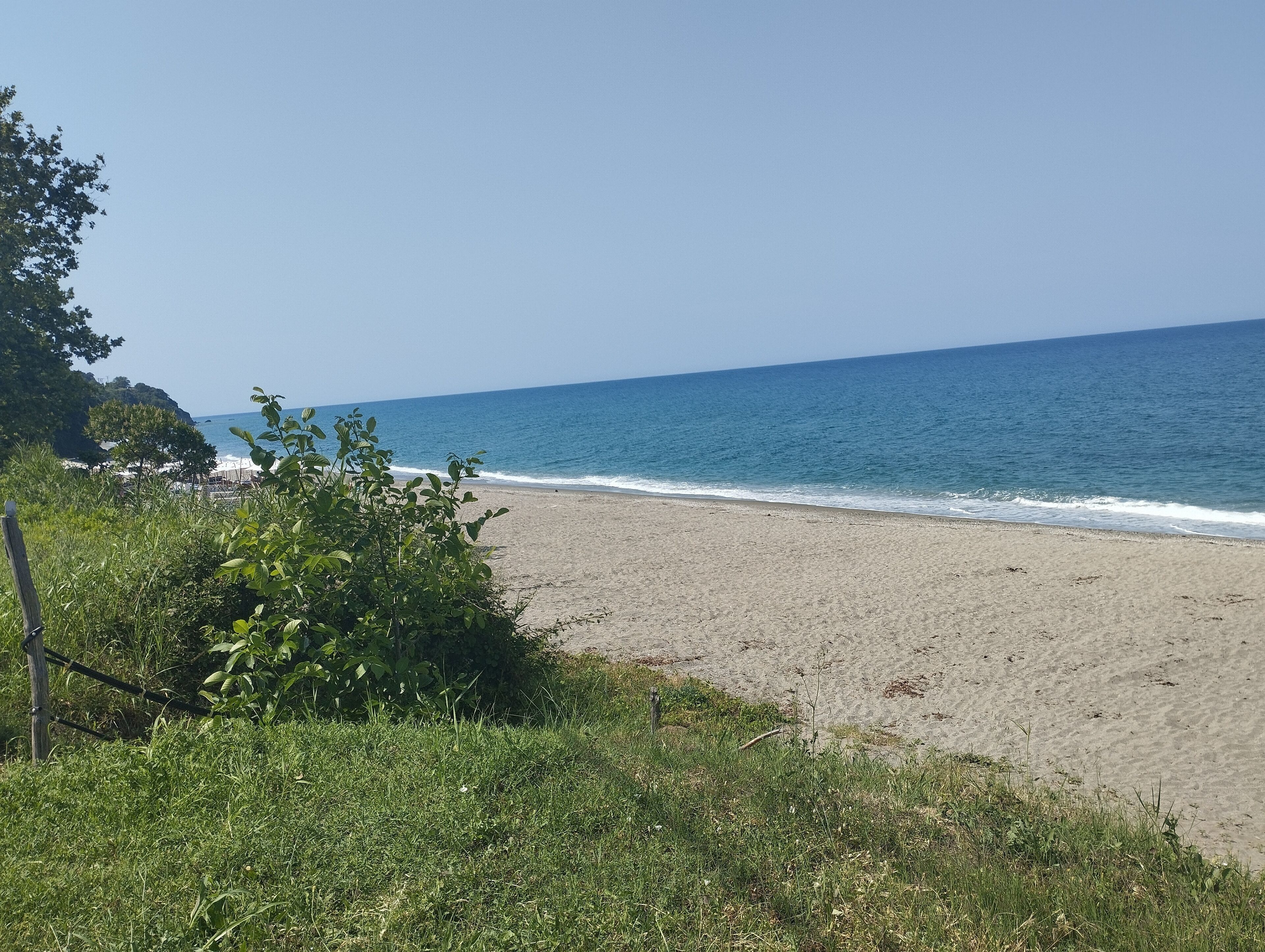 A beach with a clear sky and calm sea.