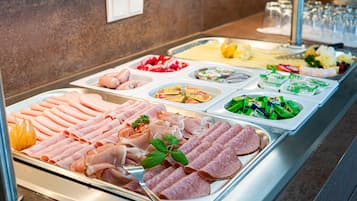 A buffet with various food options including meats, salads, and cheeses.