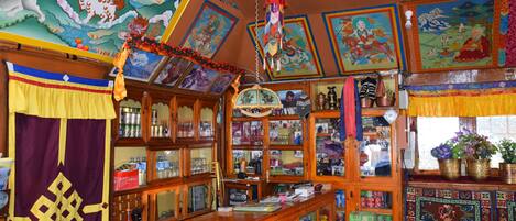 Une pièce au décor traditionnel, comprenant une fresque murale colorée, un ornement suspendu et un meuble en bois doté de portes en verre.