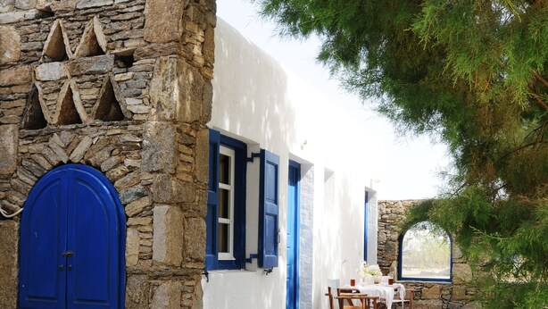 A traditional stone and white building with blue doors and windows, a stone staircase, and a table set for dining. - Katerina View Mykonos (Mykonos)