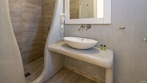 A modern bathroom with a curved shower, a large mirror, and a pedestal sink. - Katerina View Mykonos (Mykonos)