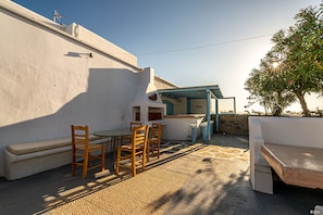 A patio with a table and chairs, a bench, and a small bar area.
