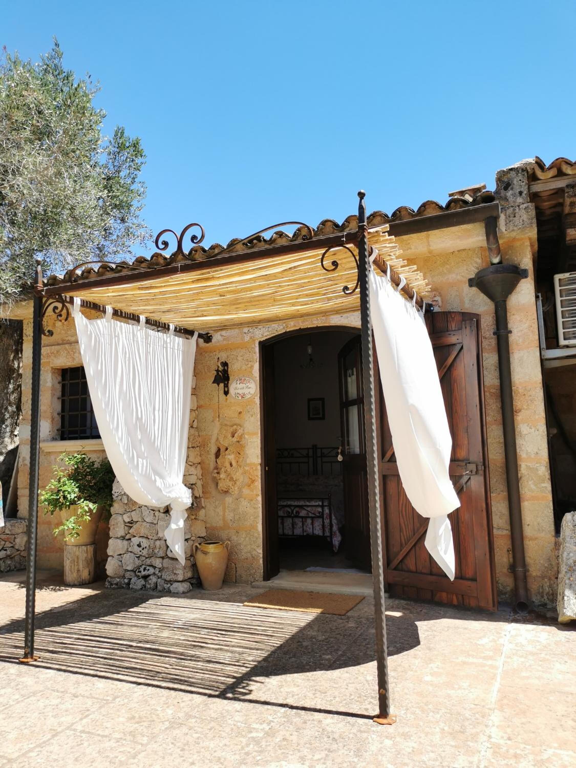 A traditional stone building with a wooden door and a metal gate.