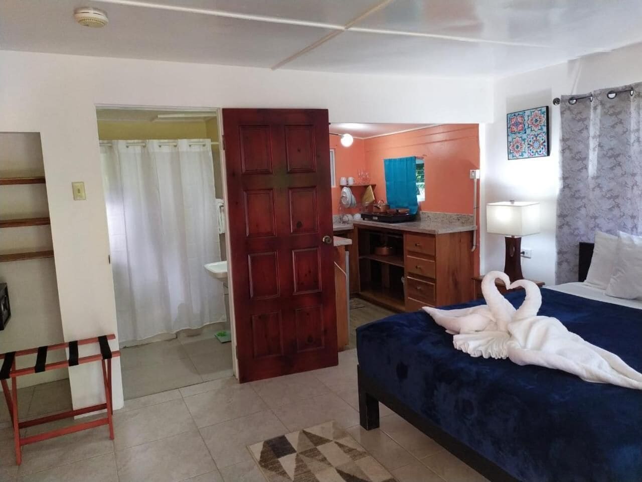 Ein Hotelzimmer mit Bett, Schreibtisch, Bad und Kleiderschrank.