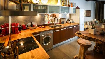 Une cuisine moderne avec des meubles en bois, un lave-vaisselle encastré et un espace dédié à la préparation du café.