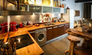 A modern kitchen with wooden cabinets, a built-in dishwasher, and a coffee station.