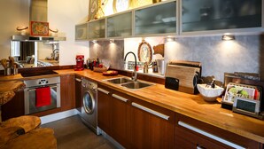 Een moderne keuken met roestvrijstalen apparatuur, houten kastjes en een ingebouwde oven.