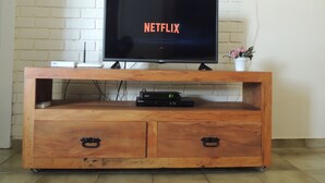 Ein TV-Schrank aus Holz mit einem Flachbildfernseher, der das Netflix-Logo zeigt.