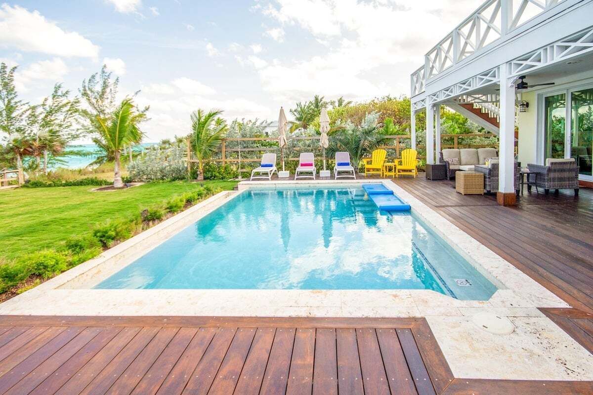 A swimming pool with lounge chairs and a wooden deck.