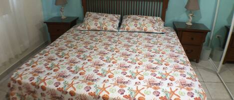 Un dormitorio con una cama, dos mesitas de noche y un espejo.