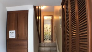 A staircase leading to a room with a wooden wardrobe and a wooden door. - OCEAN VIEW "GATED" AND ACROSS THE WYNDHAM HOTEL!!! (RIO GRANDE RIO MAR)