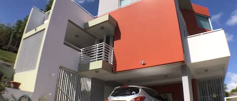 A modern two-story house with a car parked in the driveway.