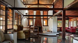 Un salón amplio con chimenea, ventanas grandes y suelo pulido.