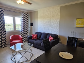 Relax in this stylish living space with a sofa, armchair, and dining table.