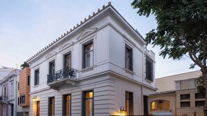 A white building with a balcony and a gated entrance. - Acropolis Whitehouse Mansion in Plaka by JJ Hospitality (Athina)