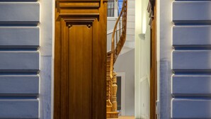 A grand wooden door leading to a staircase with a decorative metal railing. - Acropolis Whitehouse Mansion in Plaka by JJ Hospitality (Athina)
