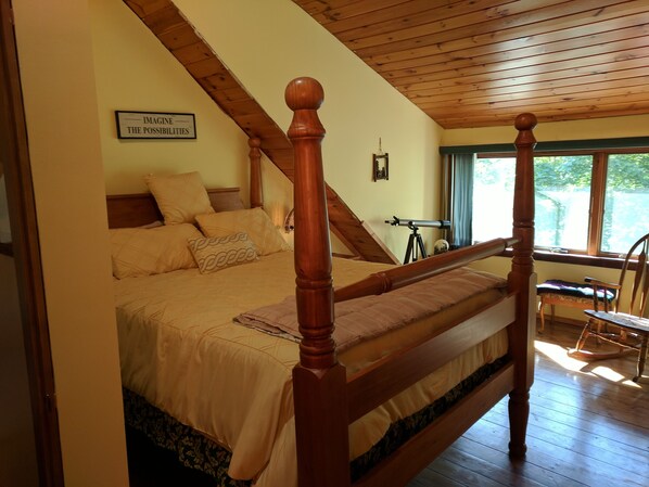 A bedroom with a four-poster bed, a telescope, and a sign reading "IMAGINE THE POSSIBILITIES". - Lakefront home with something to enjoy for every season! (Lee)