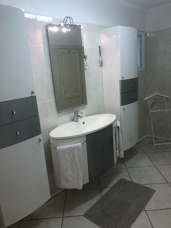 A bathroom with a white sink, a mirror, and a towel hanging on the wall. - Villa on the Southside, Breathtaking View, Pool, Air Conditioning, 5 minutes to the beach, large garage, (Roquebrune-Sur-Argens)