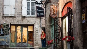 Katunäkymä, jossa on kirjakauppa nimeltä »Bibliarie le Haut Quartier» ja korukauppa nimeltä »Bijoux Kristal».