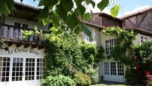 Un bâtiment traditionnel sur lequel on peut lire l’inscription « Le Cheval Blanc ».