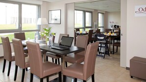 A conference room with a table, chairs, a laptop, and a window with a view of the outdoors. - Studio spacieux, près monuments historiques (Amiens)
