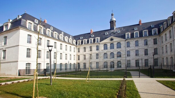 A large, classical building with a symmetrical facade, multiple windows, and a central tower. - Studio spacieux, près monuments historiques (Amiens)