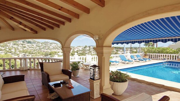 A covered outdoor seating area with a pool, overlooking a scenic hillside. - Beautifully Furnished Family Villa with Spectacular Views and Pool.  (Moriara)