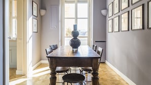 A dining area with a wooden table, chairs, and a vase centerpiece. - Milano Charming apartment, a unique home: central area, 2BDR, 2BTH, 4 Guests (Milano)