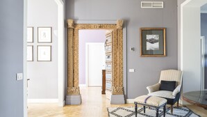 A hallway with a patterned archway, a framed picture on the wall, and a chair with a cushion. - Milano Charming apartment, a unique home: central area, 2BDR, 2BTH, 4 Guests (Milano)