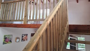 A wooden staircase with a ceiling fan, wooden beams, and a view of the outside. - Villa nanou, quiet villa top with small sea view (BOUILLANTE)