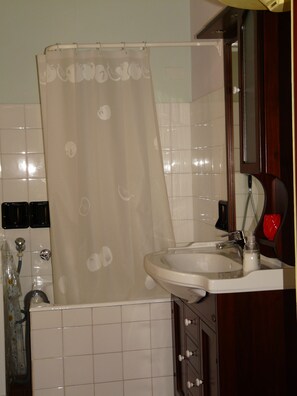 A bathroom with a shower curtain, a sink, and a mirror. - Nice small house with garden and breath-taking view over the Versilia Coast (Monteggiori)