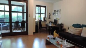 Ein Wohnzimmer mit einer Couch, einem Couchtisch und einem Essbereich mit Stühlen und einem Tisch.