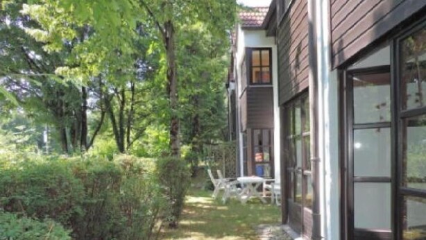 Ein Haus mit überdachter Terrasse, einem Fenster und einer Tür.