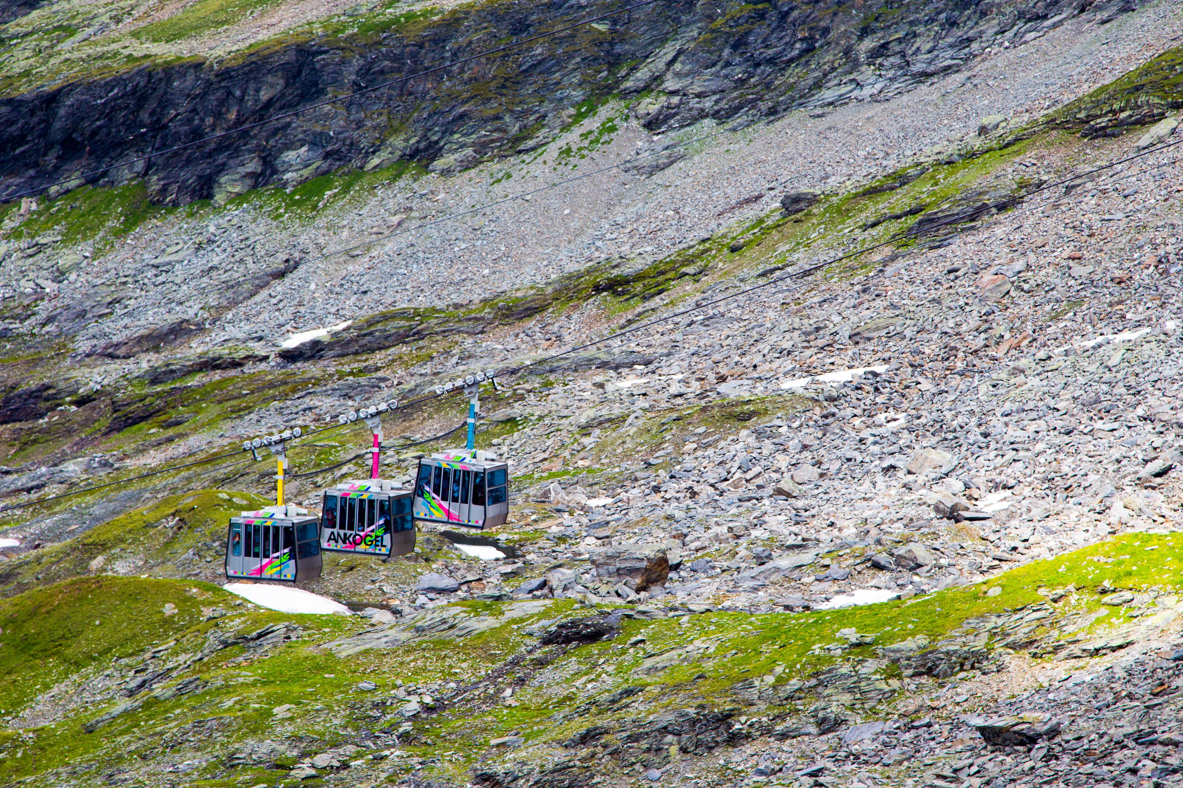 Eine Seilbahnanlage in einer gebirgigen Gegend mit felsigem Gelände und spärlicher Vegetation.
