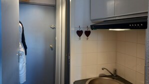 A compact kitchen with a sink, cabinets, and a hanging light fixture. - Furnished studio rental Winter/Summer Savoie ski area at the foot of the slopes (Villarembert)