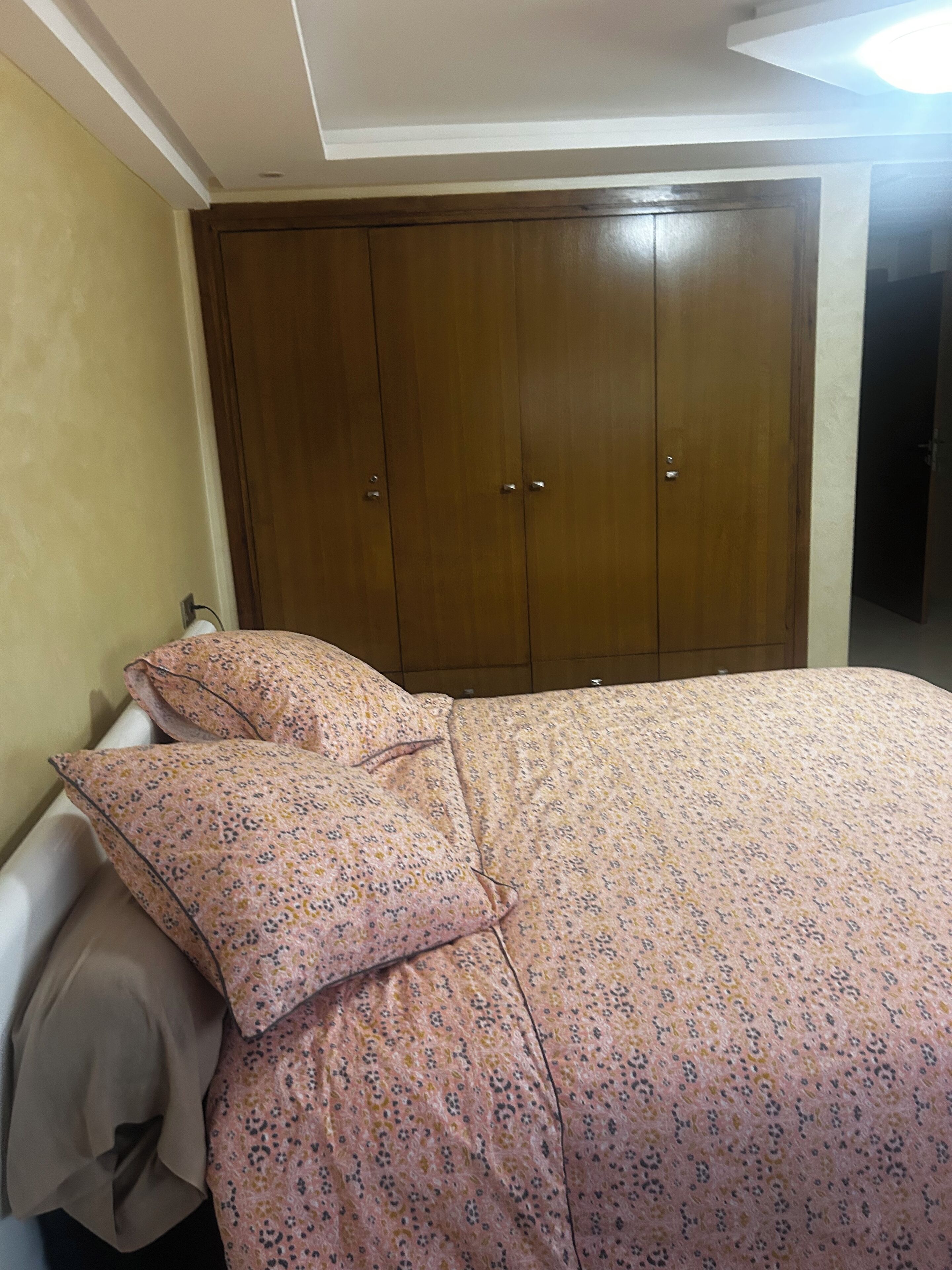 Una camera da letto con un letto, un armadio e un comodino.