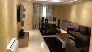 Een moderne woonkamer met een bank, salontafel en een eethoek.