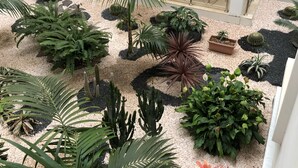 Een binnenplaats met diverse planten, een trap en metalen leuningen.
