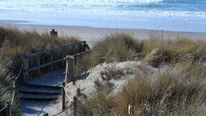 A wooden staircase leading to a beach with waves in the background. - Magical Place By The Sea. (Watsonville)