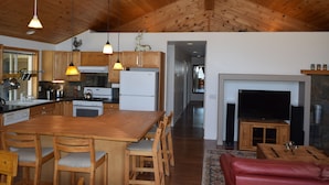 Una cocina moderna con armarios de madera, una isla central e iluminación colgante.